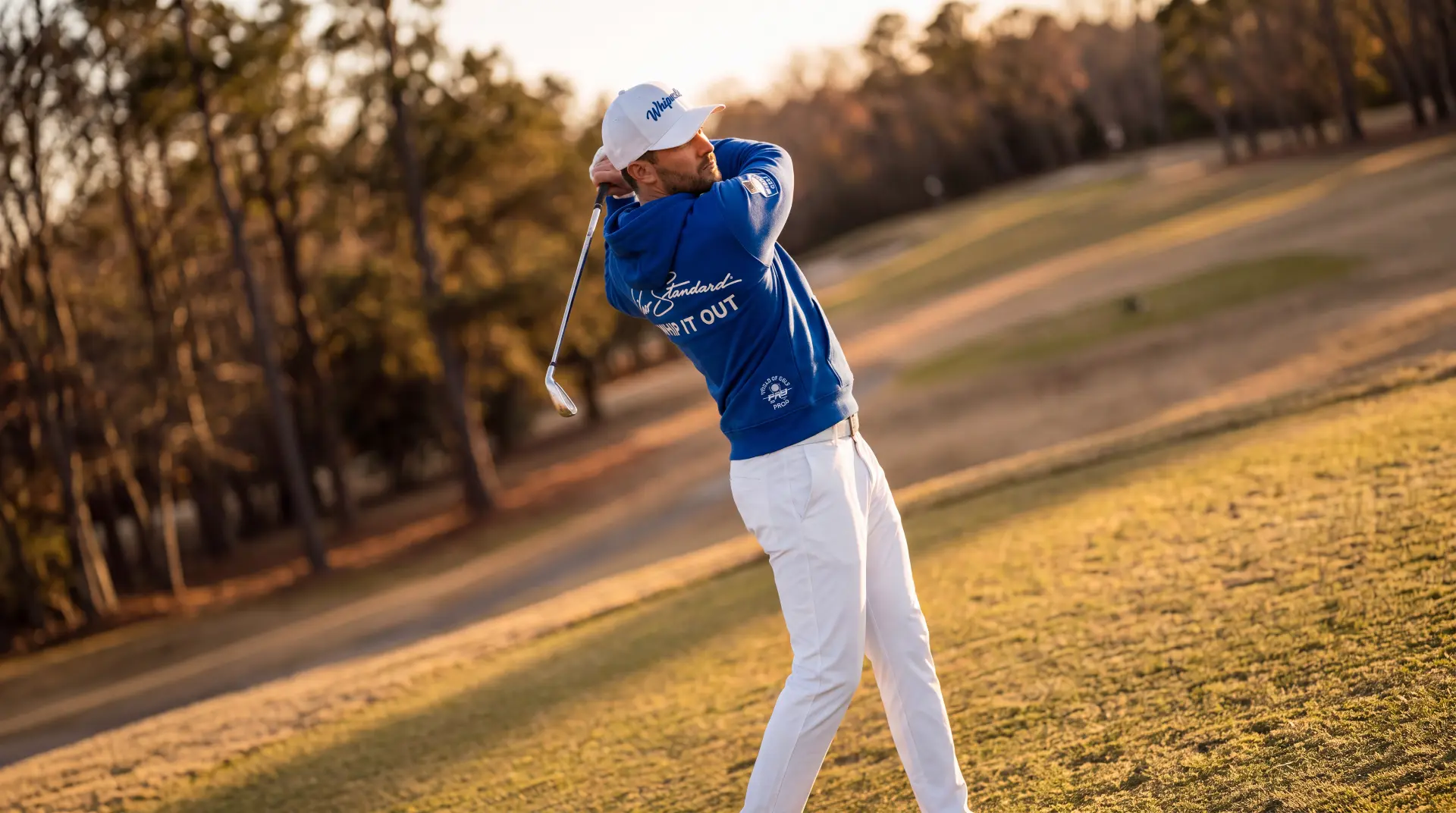 Golfer in a Pro Standard quarter-zip standing over the ball at sunset